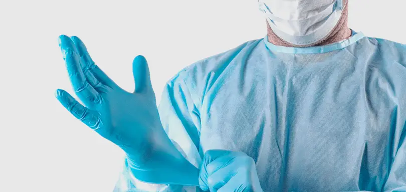 Equipo médico aplicando medidas de bioseguridad en el quirófano